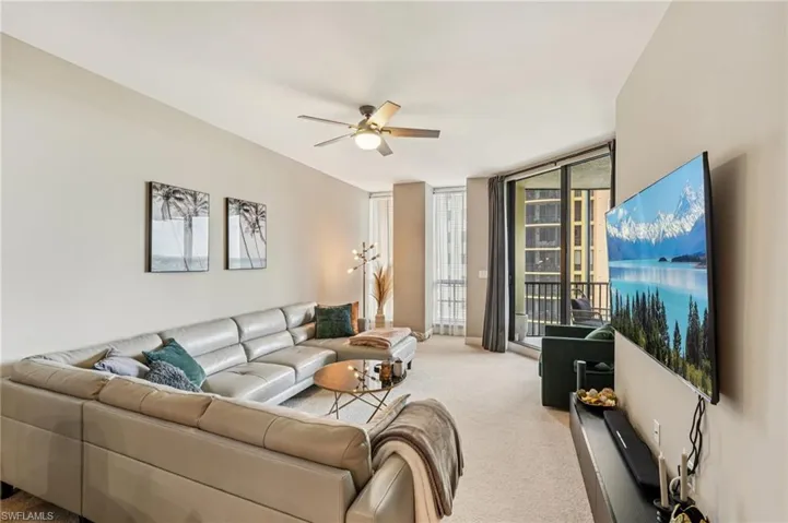 Living area featuring carpet flooring, a wall of windows, and ceiling fan