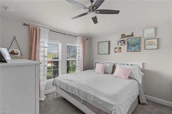 Carpeted bedroom with baseboards and ceiling fan