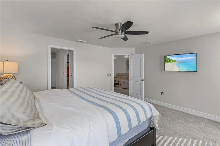 Carpeted bedroom featuring baseboards and ceiling fan