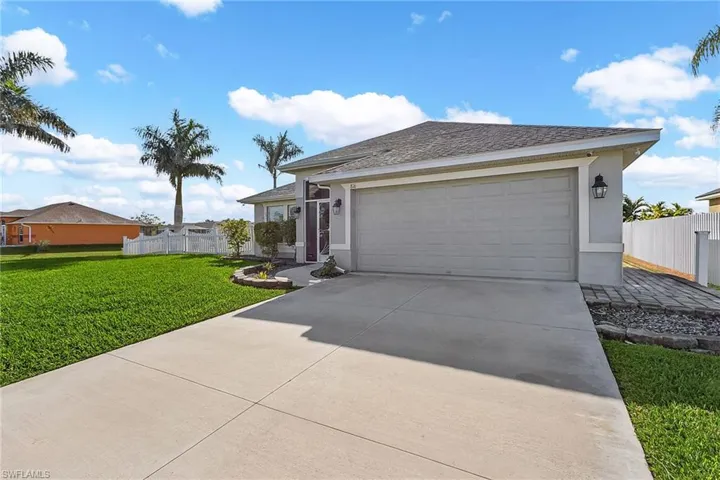 Single story home featuring concrete driveway, stucco siding, and a garage