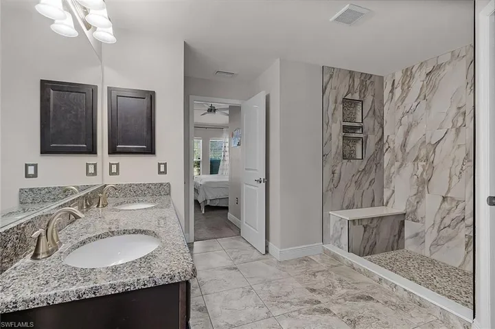 Full bathroom featuring ensuite bath, a marble finish shower, double vanity, a ceiling fan, and marble finish floors