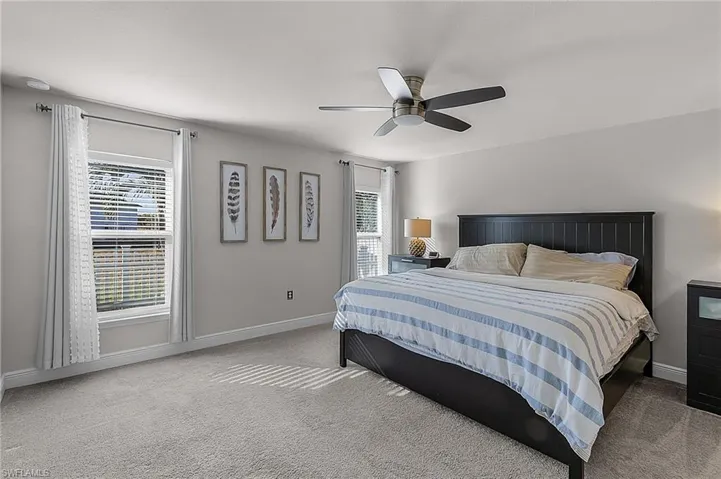 Bedroom featuring carpet floors, baseboards, and a ceiling fan