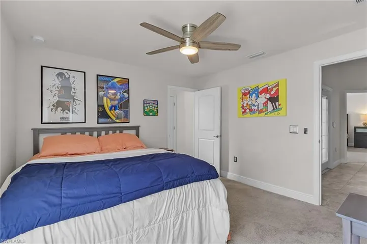 Bedroom with baseboards, carpet, and a ceiling fan
