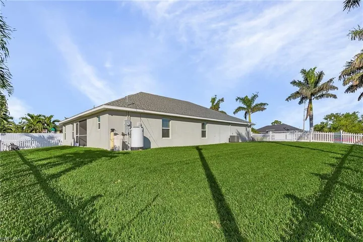 Rear view of house with stucco siding and central air condition unit