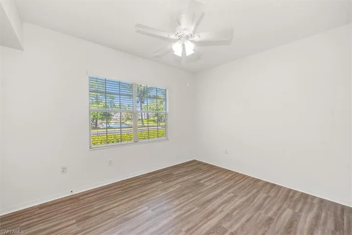 3rd bedroom featuring wood-finish flooring, a white ceiling fan with integrated lighting, and a window with horizontal blinds