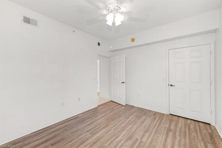 3rd bedroom featuring light wood-finish flooring, white walls, and a ceiling fan with integrated lighting