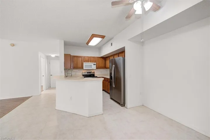 Kitchen with wood cabinetry, stainless steel appliances, and a breakfast bar