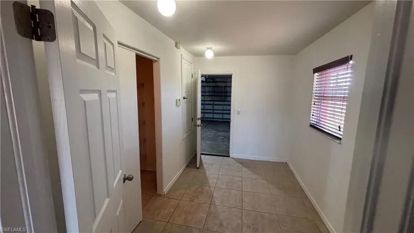 Hall featuring baseboards and light tile patterned floors