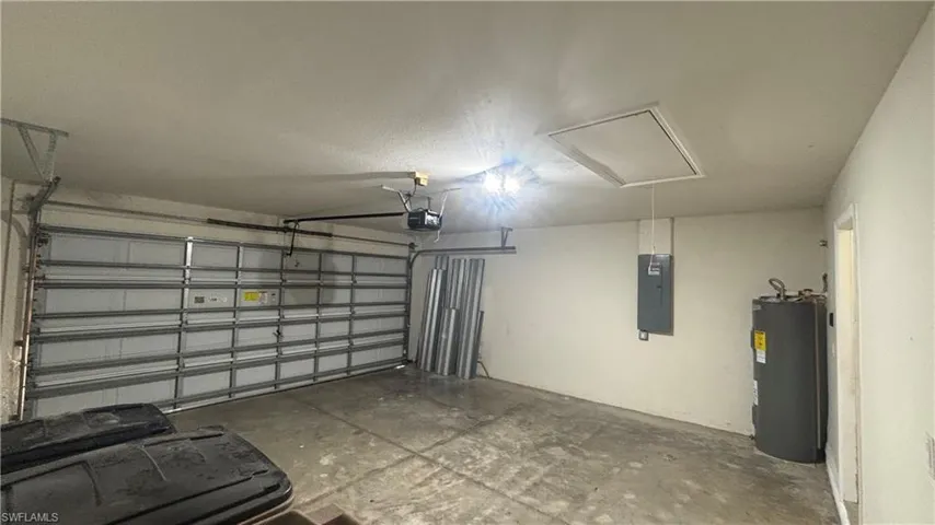 Garage featuring water heater and electric panel