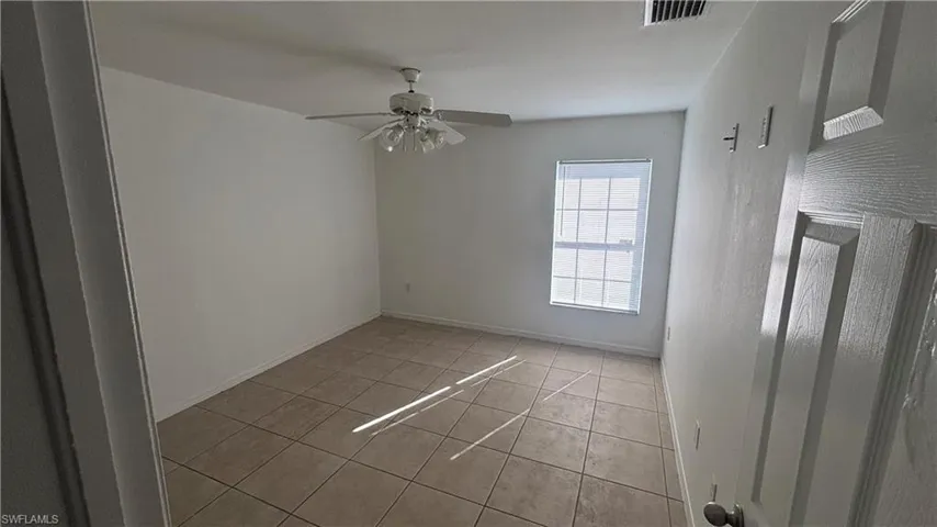 Unfurnished room featuring light tile patterned floors and ceiling fan
