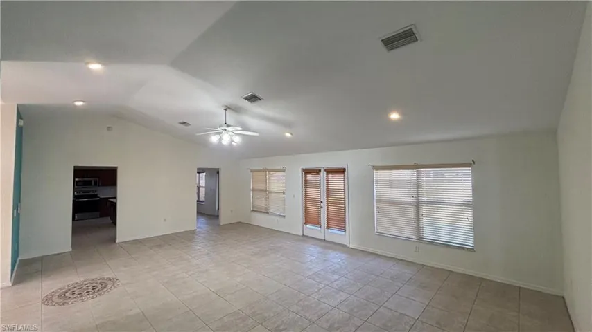Spare room with vaulted ceiling, recessed lighting, light tile patterned floors, and ceiling fan