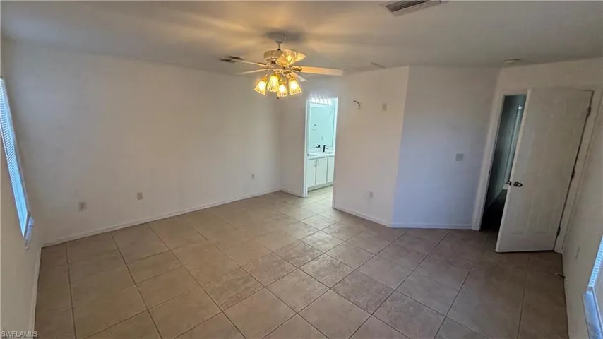 Unfurnished room featuring a ceiling fan and light tile patterned floors