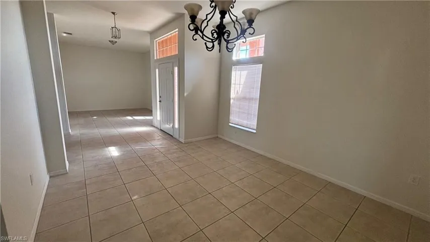 Unfurnished dining area featuring light tile patterned floors and a chandelier