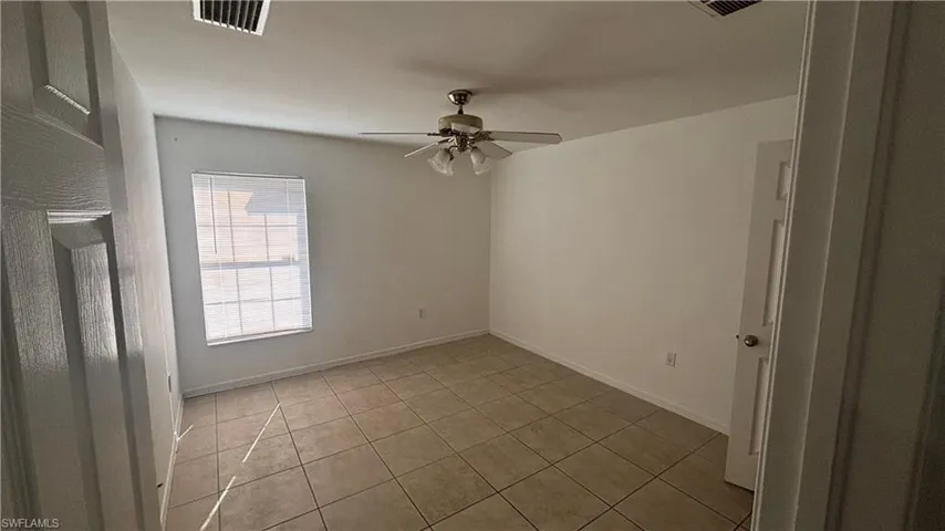 Spare room featuring light tile patterned flooring and ceiling fan