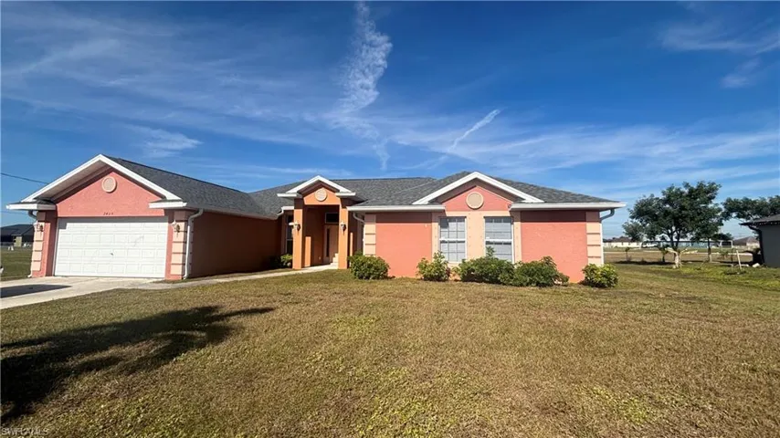Ranch-style house featuring a garage and driveway