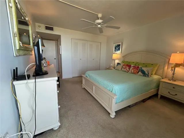 Bedroom with carpet floors, ceiling fan, and a closet