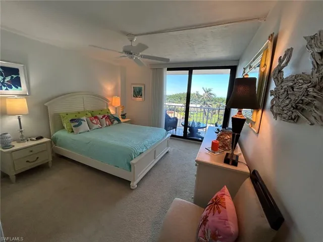 Carpeted bedroom featuring ceiling fan and access to outside