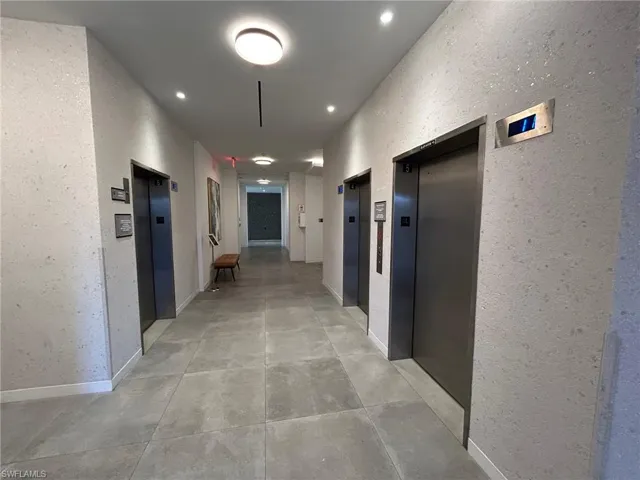 Corridor with light tile patterned floors and elevator