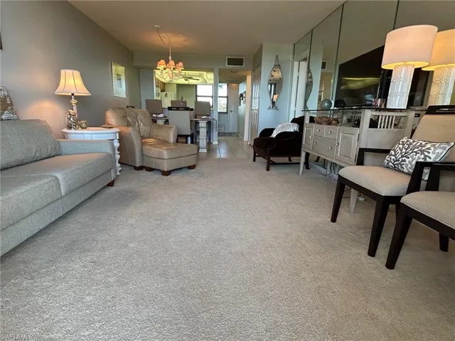 Carpeted living room featuring a chandelier