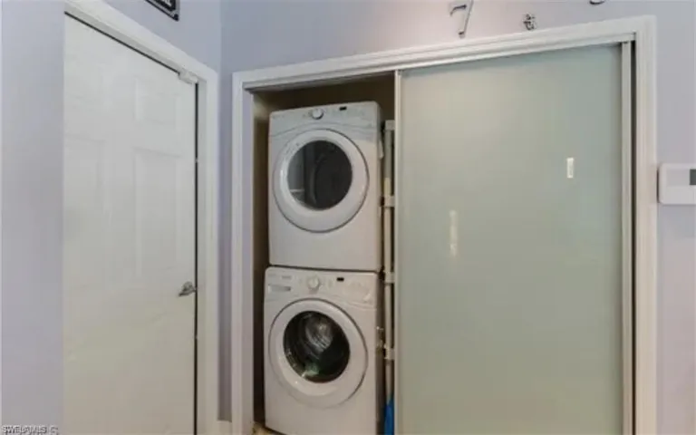 Laundry room with stacked washing machine and dryer