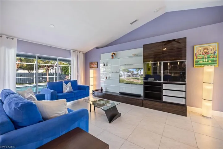 Tiled living area featuring vaulted ceiling