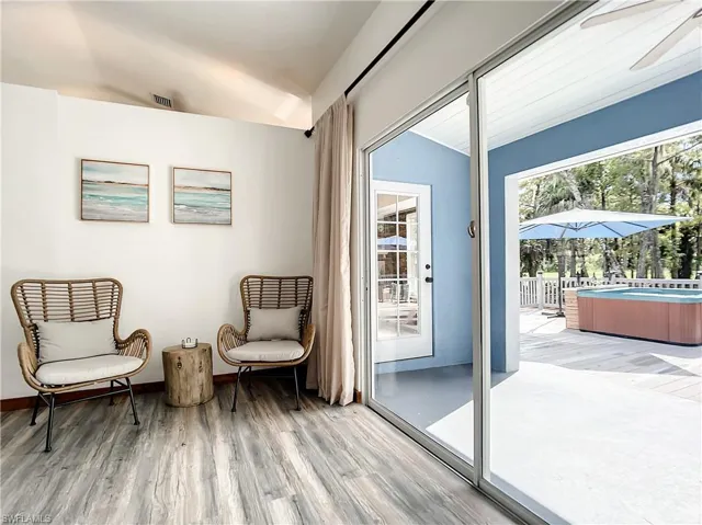 Living area featuring a sunroom, vaulted ceiling, light wood-type flooring, and a ceiling fan
