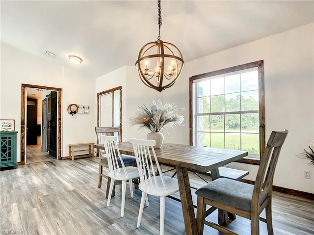 Dining area featuring lofted ceiling, light wood-style flooring, and suspended lighting