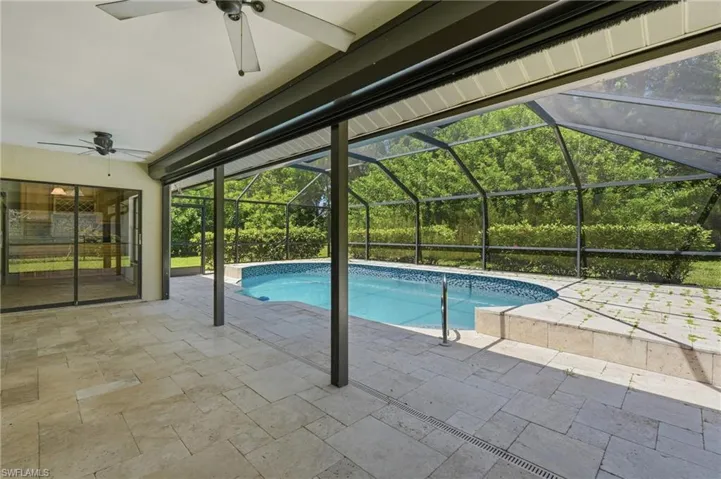 Covered patio featuring an in-ground swimming pool with a screened enclosure