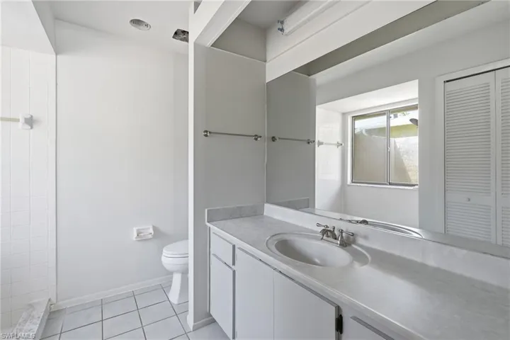 Bathroom featuring a vanity with an integrated sink, laminate countertop, and a large wall-mounted mirror