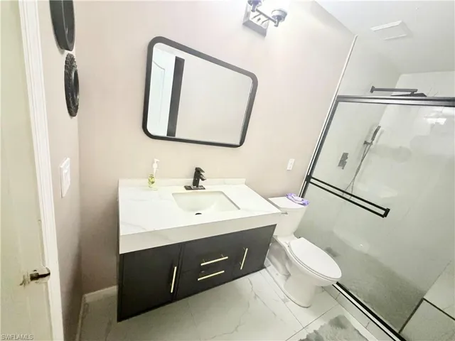Floating vanity with a white countertop and gold hardware