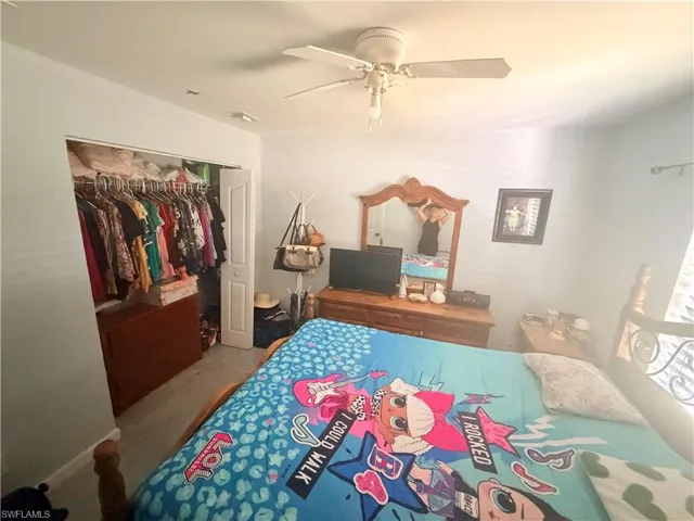 Built-in closet with bi-fold doors and a ceiling fan with light fixture