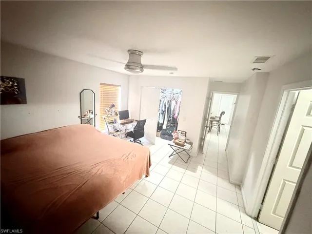 White tile flooring extends throughout, complemented by a ceiling fan with integrated lighting