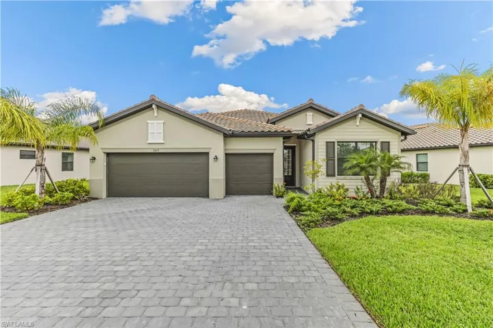 Street view of home, featuring three car garage