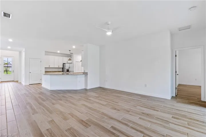 Unfurnished living room with light wood-style floors, a ceiling fan, and recessed lighting