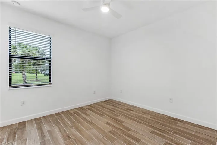 Spare room with wood tiled floors and ceiling fan