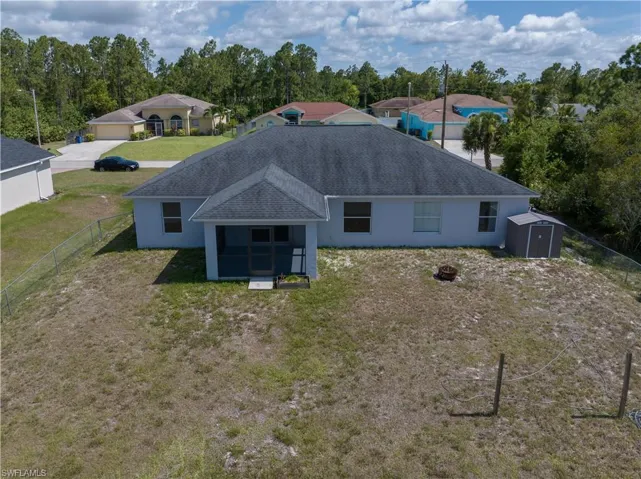 Back of property featuring a fenced yard and a storage shed