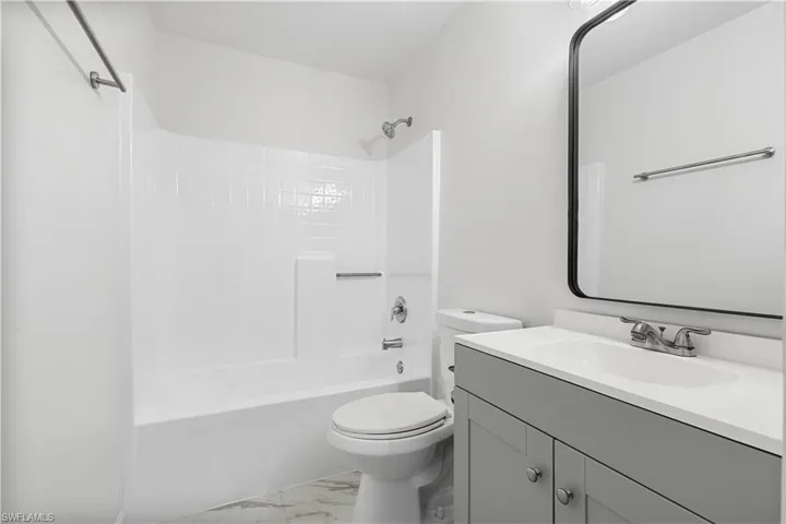 Full bathroom featuring tile floors,  shower combination, vanity, and toilet