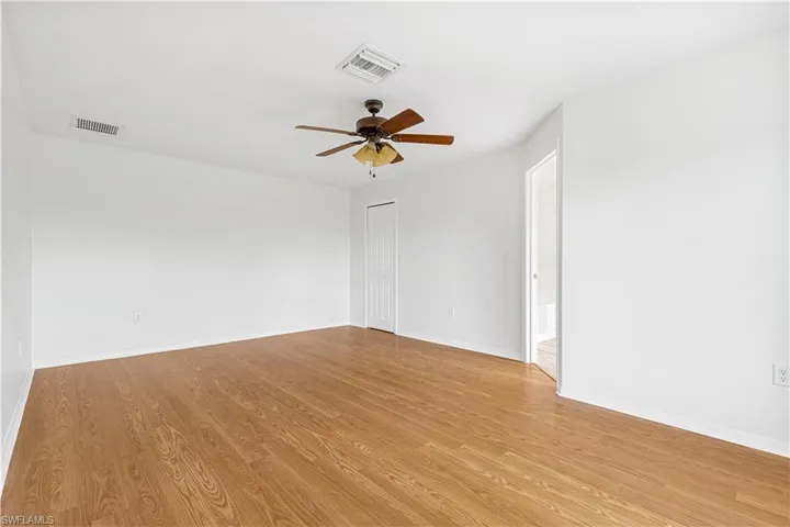 Spacious master bedroom featuring light hardwood / wood-style floors and ceiling fan