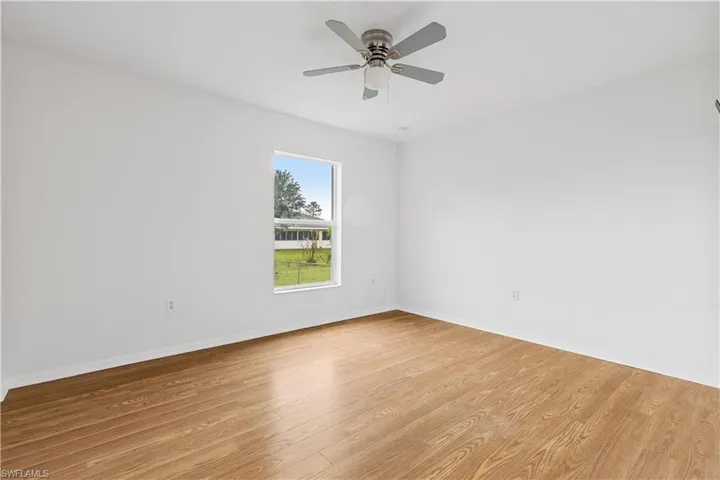 Guest room with ceiling fan and light hardwood / wood-style flooring