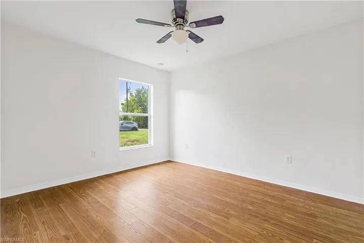 Guestyroom with wood-type flooring and ceiling fan
