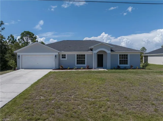 Ranch-style house featuring a front yard and a garage