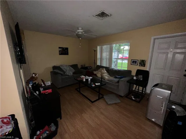 Living room featuring ceiling fan and wood-type flooring