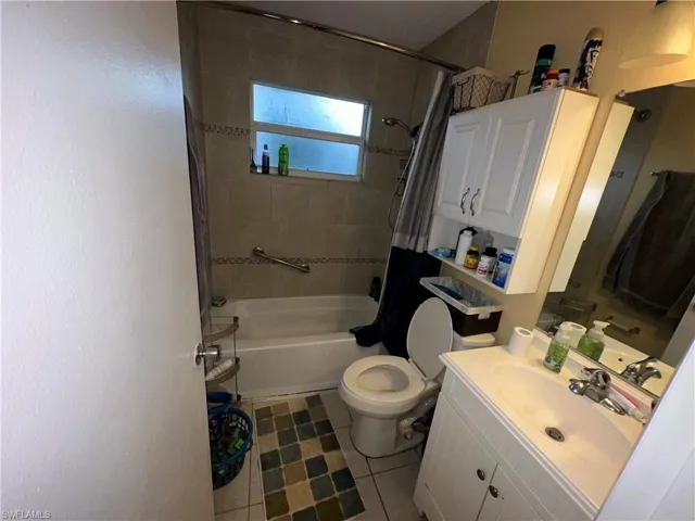 Full bathroom featuring tile patterned flooring, vanity, shower / bathtub combination with curtain, and toilet