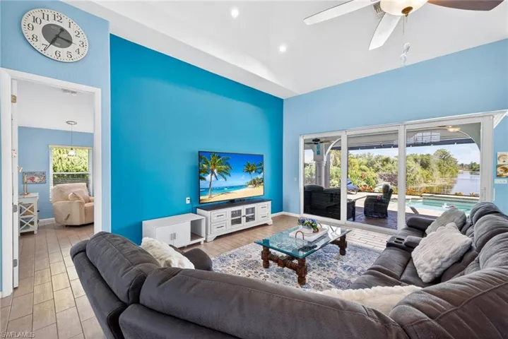 Vaulted ceilings, wood-finish flooring, sliding glass doors, ceiling fan, and recessed lighting