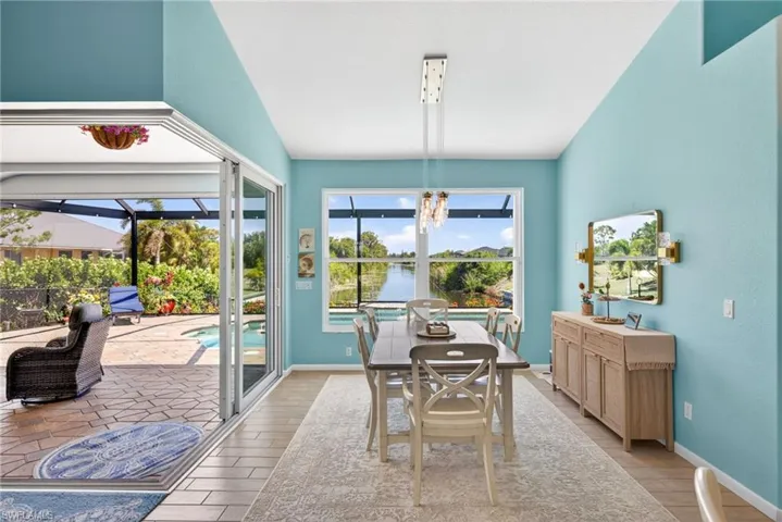 Sliding glass doors opening to a screened lanai with a paver patio and swimming pool