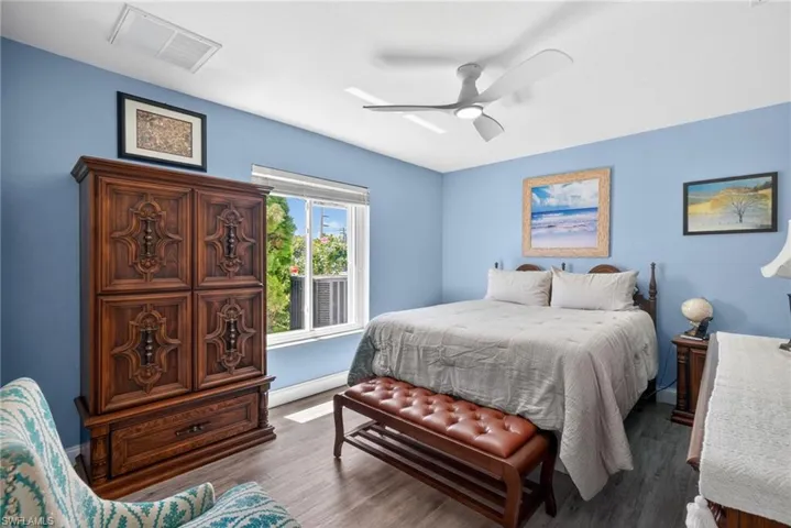 Recessed lighting, ceiling fan, window with exterior foliage, and wood-finish flooring