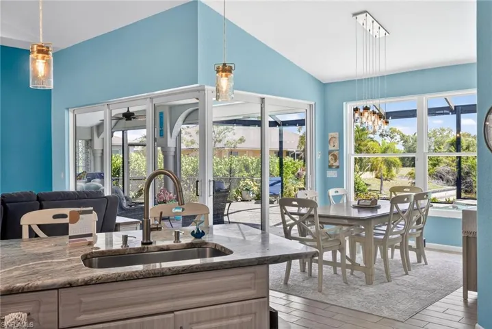 Open concept living space featuring a vaulted ceiling and a dining area with multiple windows