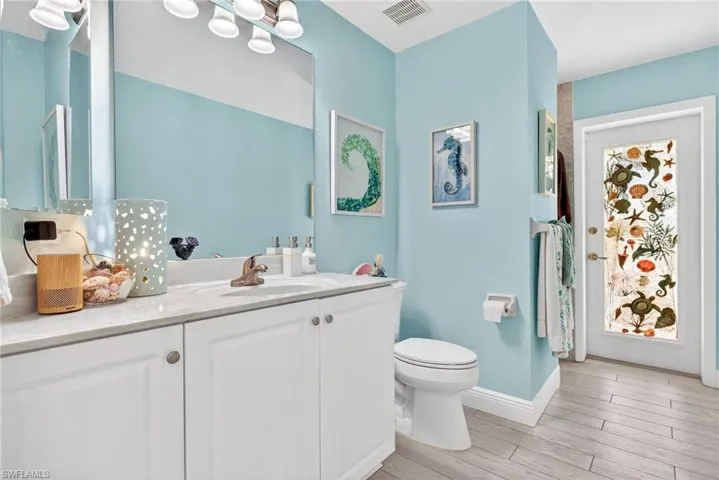 Vanity with a single sink, light-toned countertop, and white cabinetry