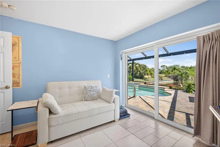 Sliding glass doors opening to a paver patio with an in-ground pool
