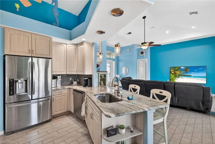 Kitchen featuring stainless steel appliances, wood-finish cabinetry, and a peninsula with a built-in sink